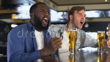 两个年轻人在酒吧里看<strong>体育比赛</strong>，碰杯啤酒，爱好